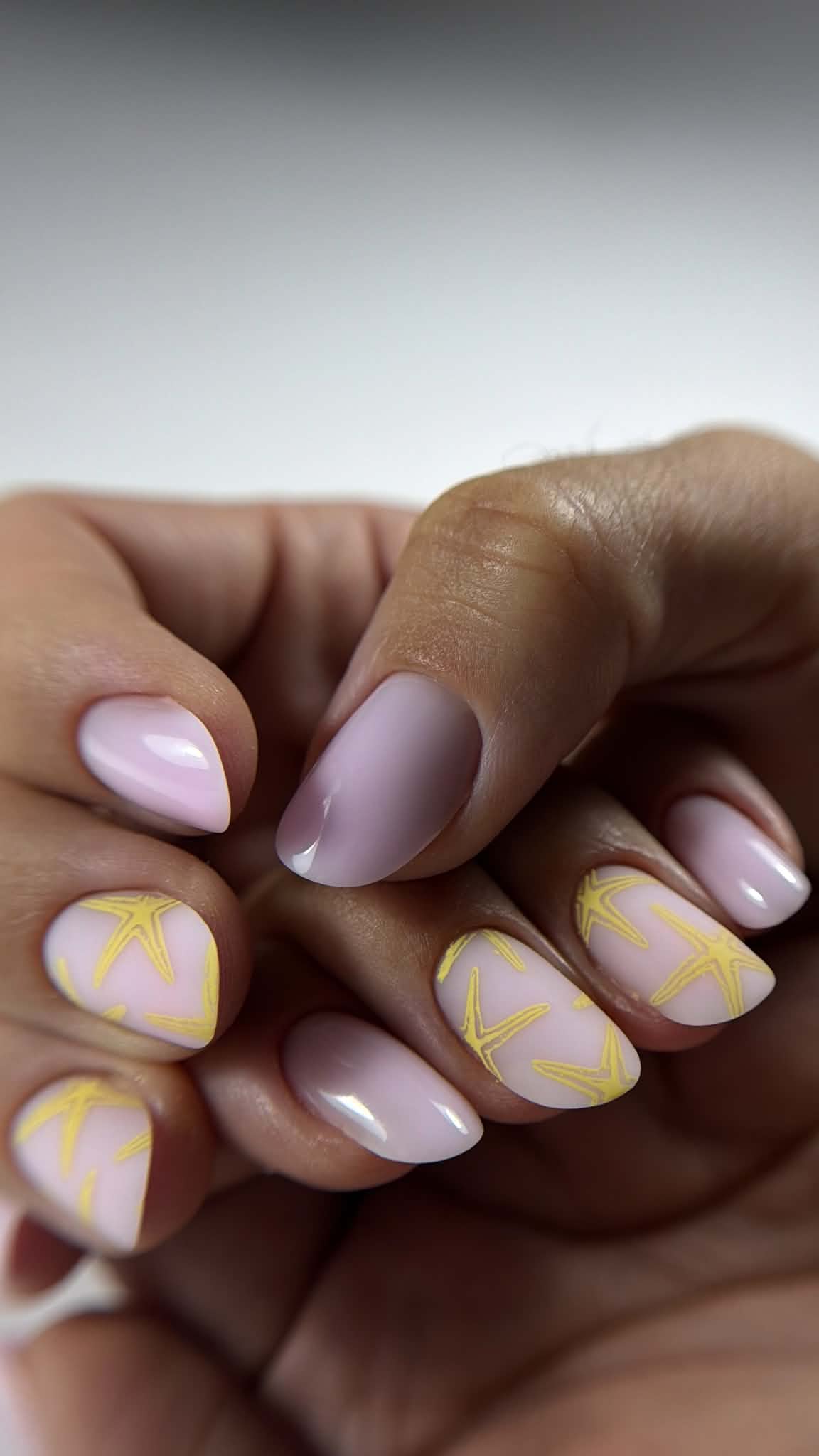 Détail d’une manucure rose et jaune